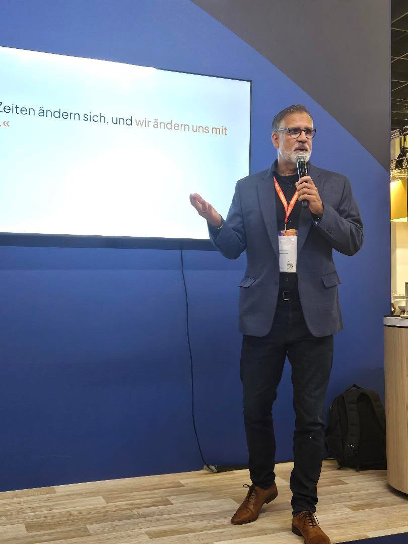Dr. Steffen Laick hält mit Mikrofon einen Vortrag auf einer Bühne